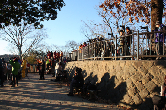 There are many photographers with tripods on the observation deck.