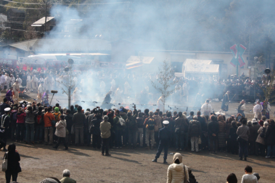 Monks crossing fire while smoke still stands.